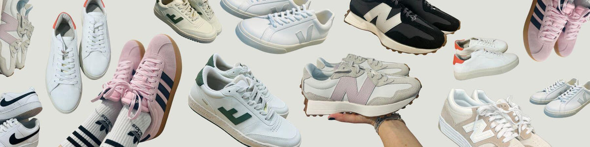 Viele weiße und bunte Sneaker auf hellem Grund, eine Hand hält einen Schuh