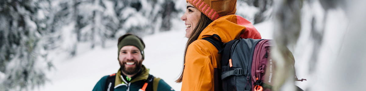 Frau und Mann sind glücklich in der Natur im Winter unterwegs.