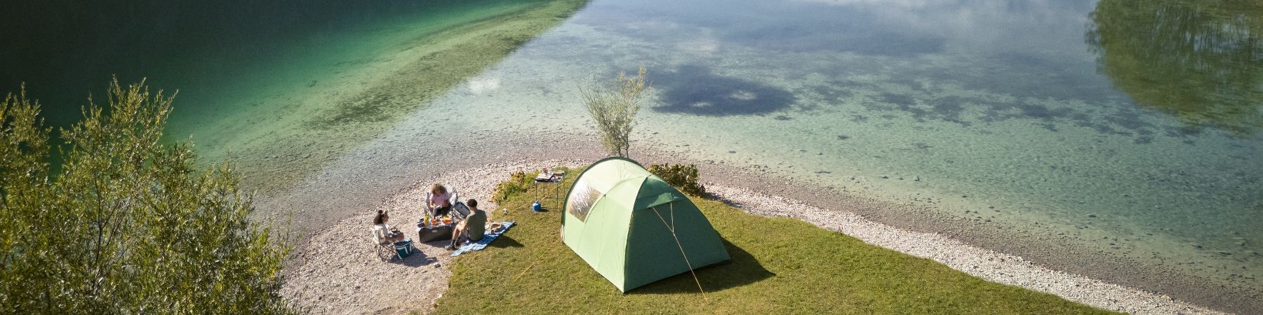 Camping am See mit Zelt und Outdoor Ausrüstung – Familie beim Zelten in der Natur