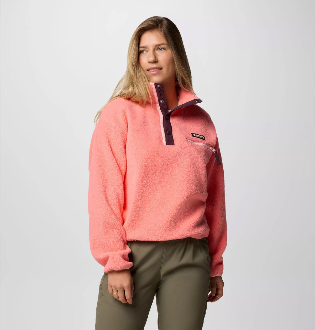 Frau in lachsfarbenem Fleecepullover mit Druckknopfleiste