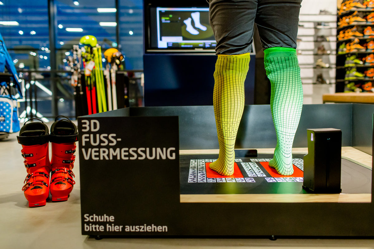 3D-Fußvermessung im Sport FÖRG Friedberg: Füße in Messstrümpfen auf dem Scanner
