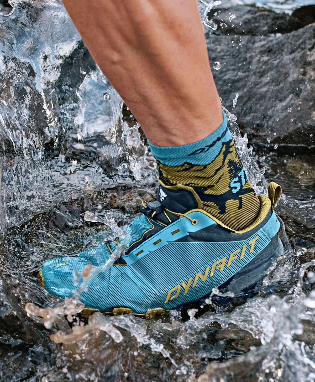 Blauer Dynafit-Trailschuh tritt in einen Gebirgsbach