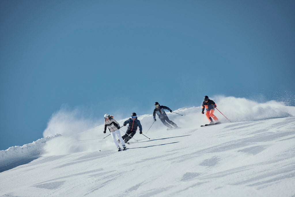 Vier Alpin Skifahrer auf der Piste